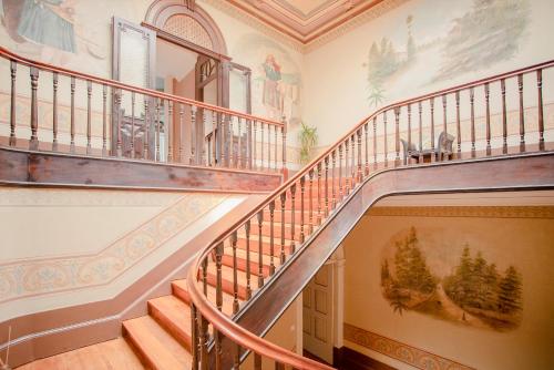 a staircase in a home with a painting on the wall at Palace Museum - Espaço Palmeiras in Porto