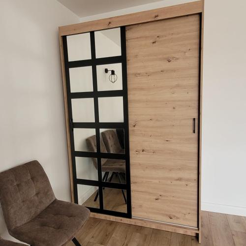 a room with a wooden door and a chair at Green Hill House in Pępice