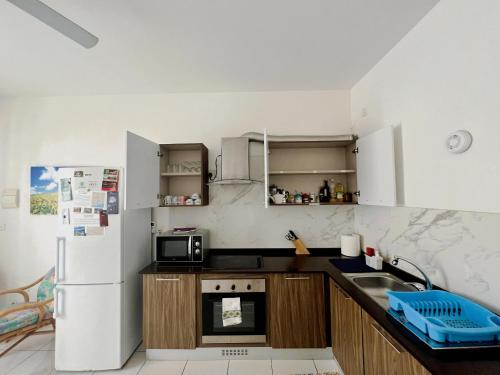 a kitchen with a refrigerator and a sink at All Nations Holiday Home in Għajnsielem