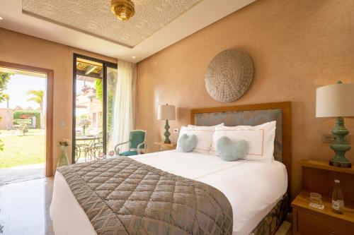 a bedroom with a large bed and a large window at Villa Dar Laila in Marrakech