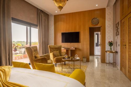 マラケシュにあるVilla Dar Lailaのベッドとテレビが備わるホテルルームです。