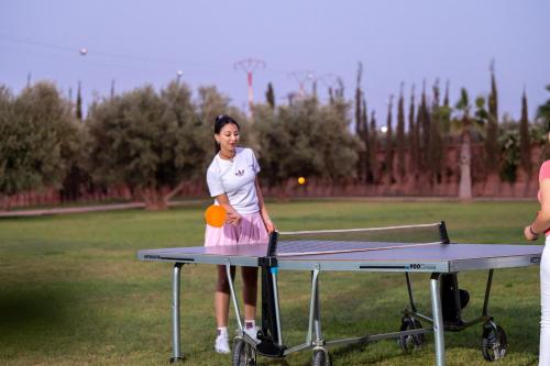 a woman standing on a ping pong table with a ball at Villa Dar Laila in Marrakech