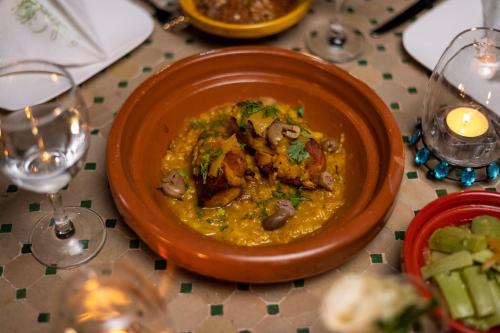 a plate of food on a table with wine glasses at Villa Dar Laila in Marrakech