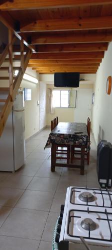 une cuisine avec une cuisinière et une table dans une pièce dans l'établissement La casa del Titi, à Tandil