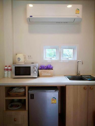 a kitchen counter with a microwave and a sink at Circle de Montana Khaoyai - เซอร์เคิล ดิ มอนทาน่า เขาใหญ่ (Moon) in Ban Rai