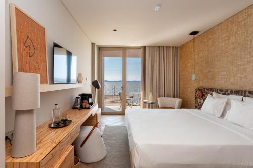 アルコシェテにあるUpon Vila - Alcochete Hotelのベッド付きのホテルルームで、海の景色を望めます。