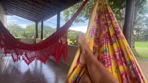 a person hanging from a hammock in a house at Refúgio Exclusivo no Meio da Natureza in Bonito
