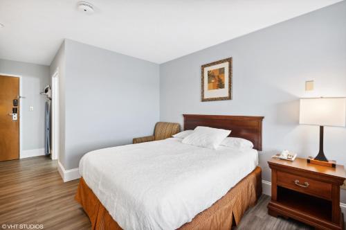 a bedroom with a large bed and a table with a lamp at My Hometown Inn in Mooresville