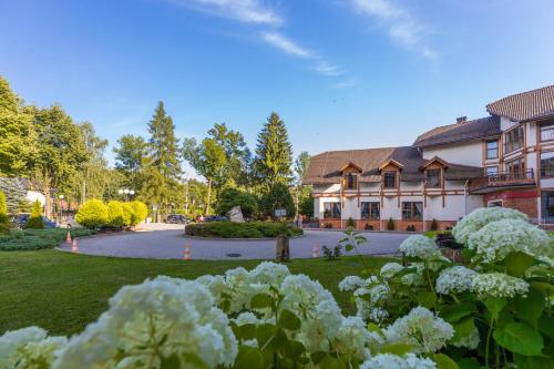 a house with a yard with flowers in front of it at Hotel Wisła Premium in Wisła