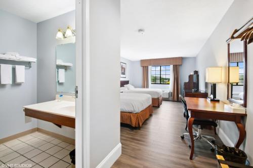 a hotel room with two beds and a desk and a sink at My Hometown Inn in Mooresville