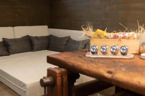 a couch sitting in a room with a table at Al Fogolâr Rooms & Osteria with Saunaland in Tolmezzo