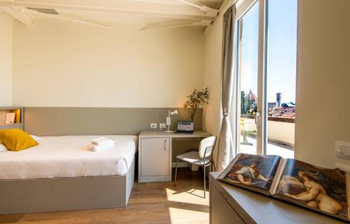 een slaapkamer met een bed, een bureau en een raam bij Il Santo Stays in Florence