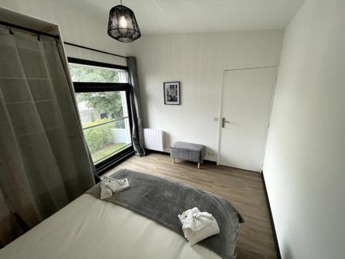 1 dormitorio con cama y ventana grande en Superbe loft lumineux à Caen, en Caen