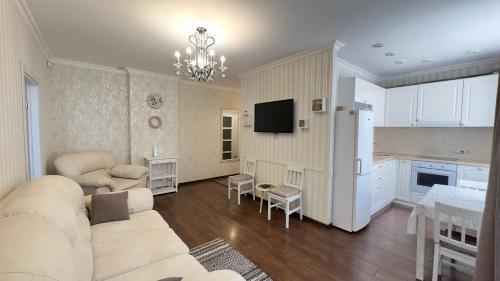 a living room with a white couch and a kitchen at Apartment in the Centre of City in Dnipro