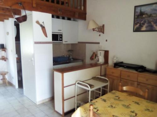 une cuisine avec un réfrigérateur et une table à l'intérieur dans l'établissement Le seringat 46, à Saint-Martin-de-Brômes