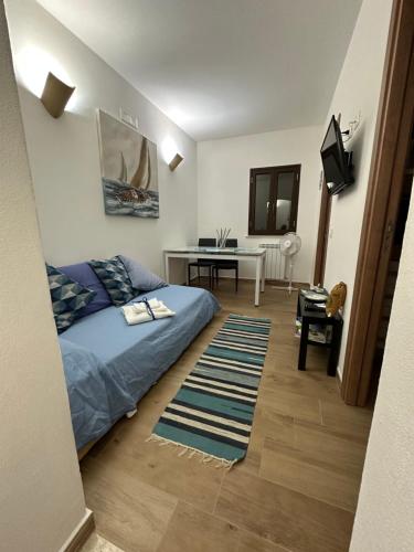 a bedroom with a bed and a desk with a television at Sale e Vele Apartments in Trapani