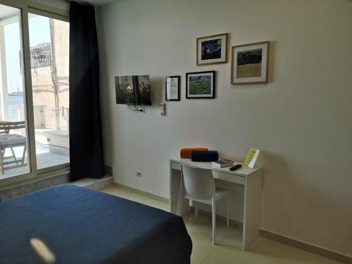 1 dormitorio con escritorio, 1 cama y ventana en Tulla's en Giardini Naxos