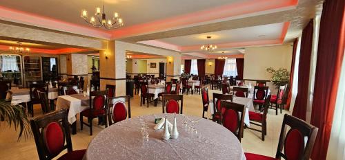 a restaurant with a table and chairs in a room at Pensiune Restaurant Pizzerie 2 Păuni in Borşa