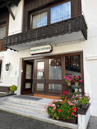 a fusion science building with flowers in front of it at Pension Steiner, 6143 Matrei am Brenner!!Check-in between 15 - 21 o'clock!! No breakfast in Mühlbachl