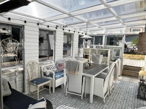a screened in porch with a table and chairs at Strandnära mysig stuga med generösa utvändiga ytor in Mellbystrand