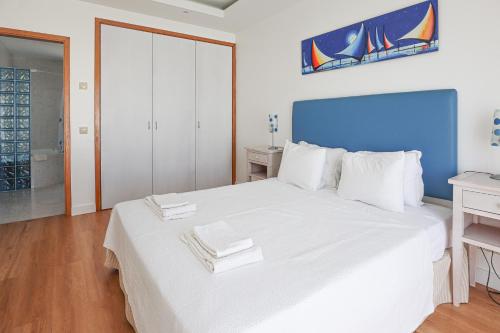 a bedroom with a white bed with towels on it at Villa Mar Ali - JACUZZI - 400m from the beach - BY BEDZY in Albufeira