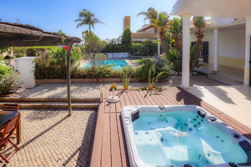 a backyard with a hot tub on a wooden deck at Villa Mar Ali - JACUZZI - 400m from the beach - BY BEDZY in Albufeira