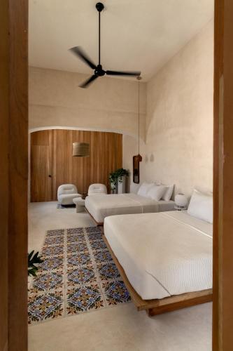 a bedroom with two beds and a ceiling fan at Narrativ Lofts - Lira - Mid Century Cozy Retreat in Campeche