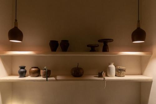 a shelf with pots and vases on it at Narrativ Lofts - Lira - Mid Century Cozy Retreat in Campeche