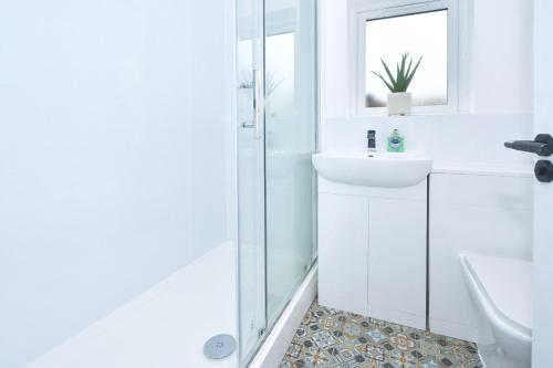 a white bathroom with a sink and a shower at GREEN DOOR in Etruria