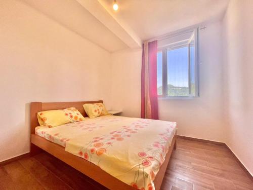 a small bedroom with a bed and a window at Talia Apartments in Budva