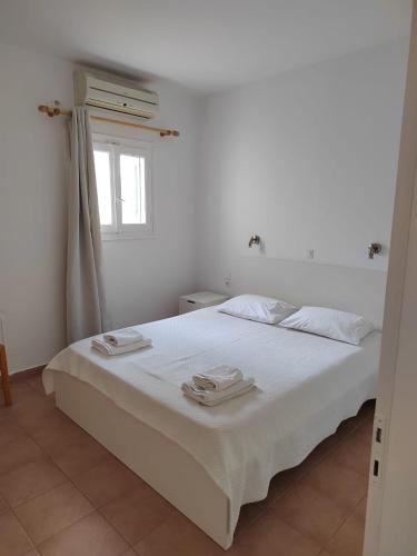 a bedroom with a white bed with towels on it at Andreana's House in Antiparos