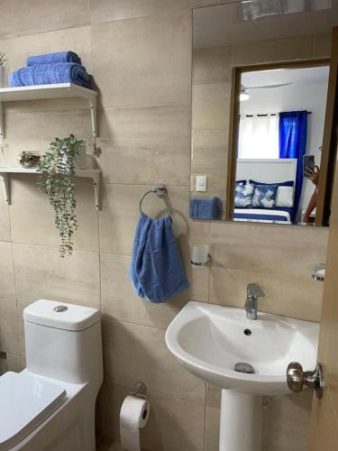 bagno con lavandino, servizi igienici e specchio di Apartamento de 3 habitaciones con piscina en la autopista Duarte a Santo Domingo