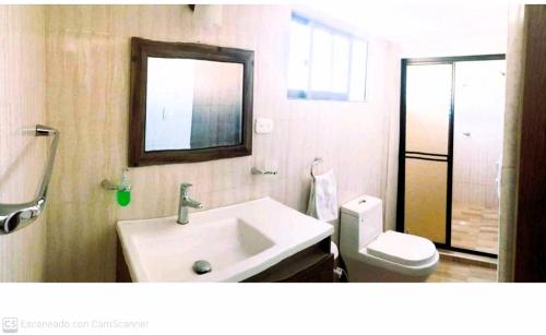 a bathroom with a sink and a toilet and a mirror at TROPICAL OCEAN SAI in San Andrés