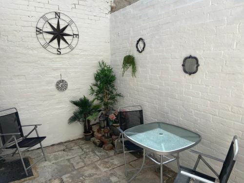 a room with a table and chairs and a brick wall at A Stones Throw to the Beach :-) in Weymouth