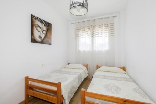 2 Betten in einem Zimmer mit Fenster in der Unterkunft Apartamento Fénix in Granada