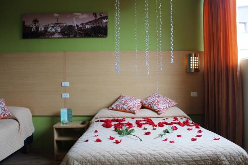 een slaapkamer met een bed met rode rozen erop bij Hostal Terra 4 - EL LABRADOR in Quito