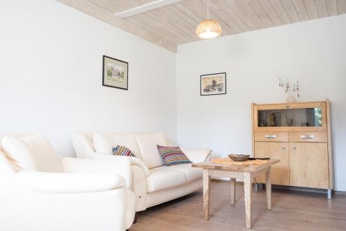 a living room with a white couch and a table at Korzenny Domek in Korzenna