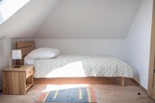 a bedroom with a bed and a table with a pillow at Korzenny Domek in Korzenna