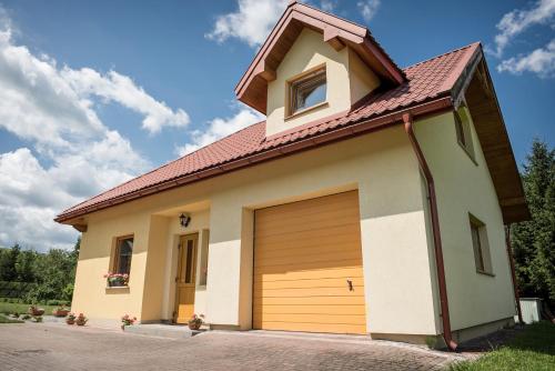 a detached garage with a brown garage door at Korzenny Domek in Korzenna