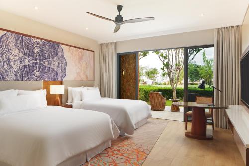 a hotel room with two beds and a tv at The Westin Desaru Coast Resort in Desaru