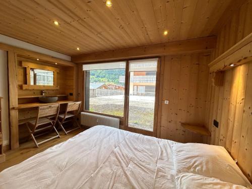 Cette chambre en bois comprend un grand lit. dans l'établissement Charmant appartement aux Gets - 8 pers, 350m du centre, terrasse et balcon - FR-1-623-90, aux Gets