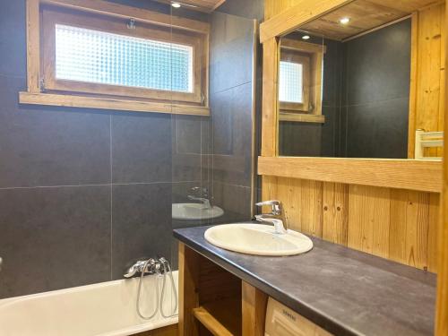 une salle de bain avec un lavabo, une baignoire et un miroir dans l'établissement Charmant appartement aux Gets - 8 pers, 350m du centre, terrasse et balcon - FR-1-623-90, aux Gets
