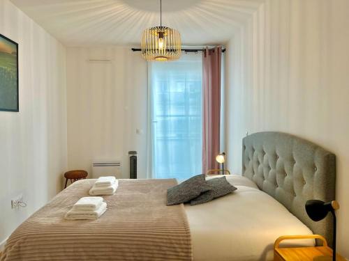 een slaapkamer met een groot bed en handdoeken bij Hermès - Reims en grand in Reims
