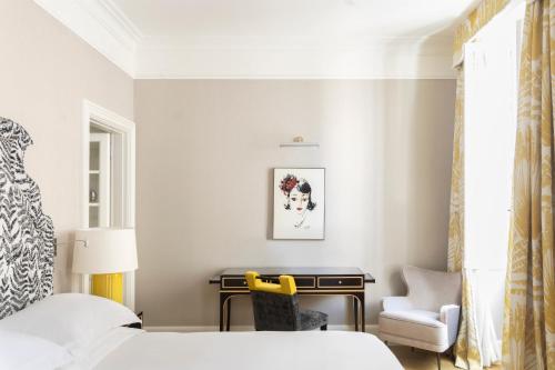 a bedroom with a bed and a desk and a chair at Maalot Roma - Small Luxury Hotels of the World in Rome