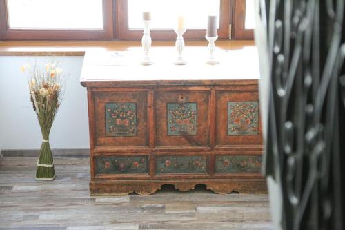 a wooden cabinet with three candles on top and a vase at Gasthof Leitner - Der Wirt an der Klamm in Donnersbach
