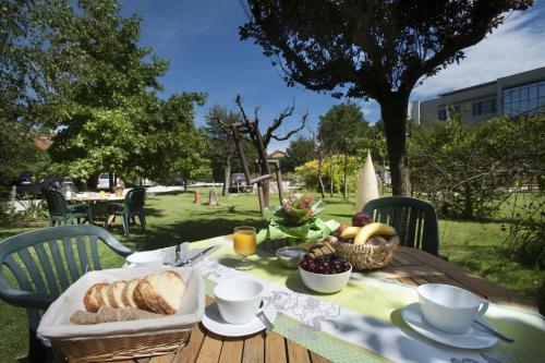 a table with bread and a basket of fruit on it at Hotel Langhe in Alba