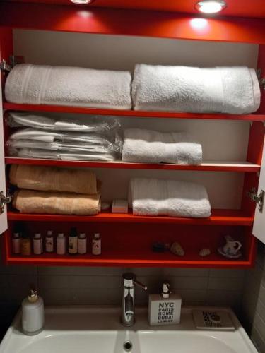 a bathroom with a red shelf with towels and a sink at Retro Central in Thessaloniki