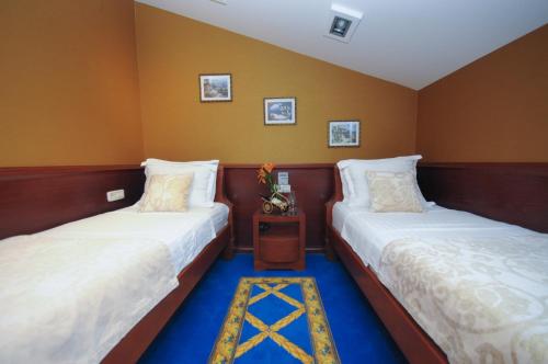 two beds in a room with yellow walls at Luxury Sea Residence by Kristina in Tivat