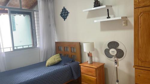 um quarto com uma cama, uma ventoinha e uma janela em Habitación Alborada 2 con baño privado em Lima