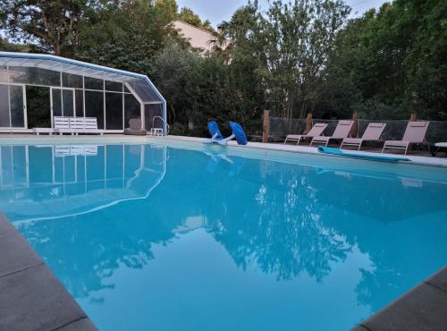 - une piscine avec des chaises et de l'eau bleue dans l'établissement Appartement Cécile - campagne avec piscine commune - Eyragues, à Eyragues